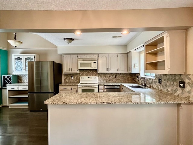 2811 Chatelain Ct Unit A, Independence, MO 64057 - kitchen featuring appliances with stainless steel finishes, a peninsula, open shelves, light stone counters, and backsplash