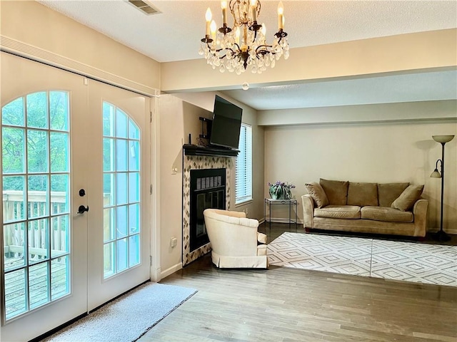 2811 Chatelain Ct Unit A, Independence, MO 64057 - living area featuring a chandelier, wood finished floors, a glass covered fireplace, and french doors