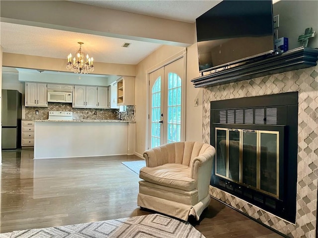 2811 Chatelain Ct Unit A, Independence, MO 64057 - living room featuring a chandelier, wood finished floors, french doors, and a glass covered fireplace