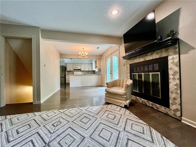 2811 Chatelain Ct Unit A, Independence, MO 64057 - living room with a glass covered fireplace, dark wood finished floors, a chandelier, and a textured ceiling