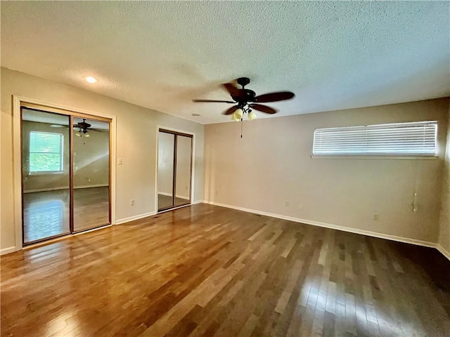 2811 Chatelain Ct Unit A, Independence, MO 64057 - unfurnished bedroom with wood-type flooring, multiple closets, a textured ceiling, and ceiling fan