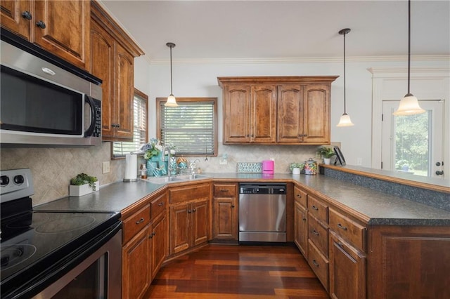 3132 SW Damon Ln, Lees Summit, MO 64082 - kitchen featuring appliances with stainless steel finishes, dark countertops, dark wood finished floors, a peninsula, and crown molding