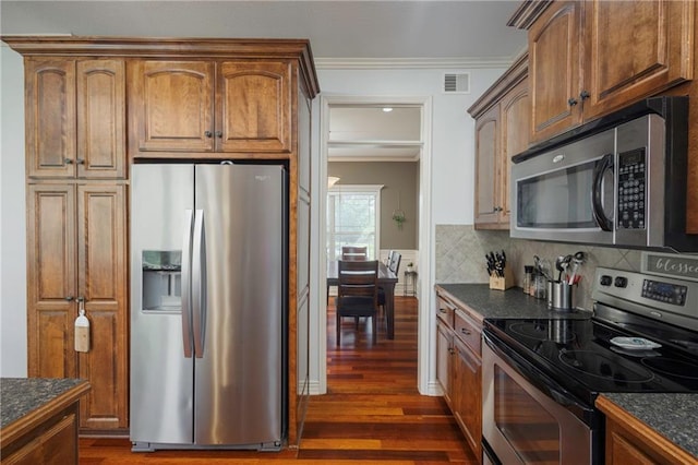 3132 SW Damon Ln, Lees Summit, MO 64082 - kitchen featuring stainless steel appliances, crown molding, dark wood-style floors, decorative backsplash, and brown cabinets