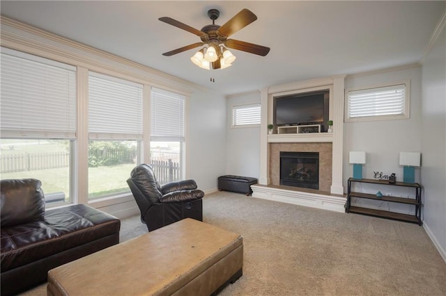 3132 SW Damon Ln, Lees Summit, MO 64082 - living area featuring a tile fireplace, carpet flooring, a ceiling fan, and crown molding