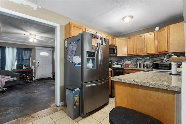 2712 S 52nd St, Kansas City, KS 66106 - kitchen featuring stainless steel appliances, a textured ceiling, decorative backsplash, light countertops, and ceiling fan