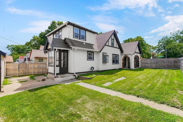 7101 Harrison St, Kansas City, MO 64131 - back of property featuring a shingled roof, stucco siding, a fenced backyard, a patio area, and entry steps