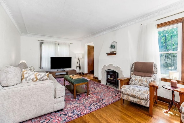 7101 Harrison St, Kansas City, MO 64131 - living room with wood finished floors, crown molding, a fireplace, and arched walkways