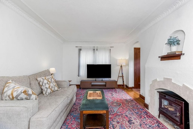 7101 Harrison St, Kansas City, MO 64131 - living room featuring wood finished floors, arched walkways, ornamental molding, and a wood stove