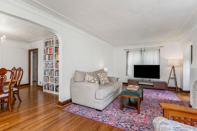 7101 Harrison St, Kansas City, MO 64131 - living area featuring wood finished floors, arched walkways, crown molding, and built in features
