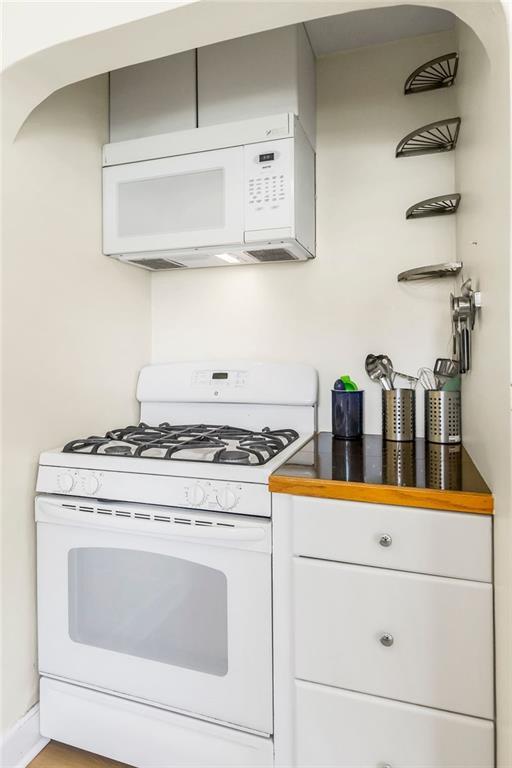 7101 Harrison St, Kansas City, MO 64131 - kitchen featuring white appliances and white cabinets