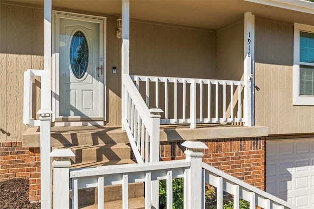 1916 NE Patterson Dr, Lees Summit, MO 64086 - property entrance featuring covered porch, an attached garage, and brick siding
