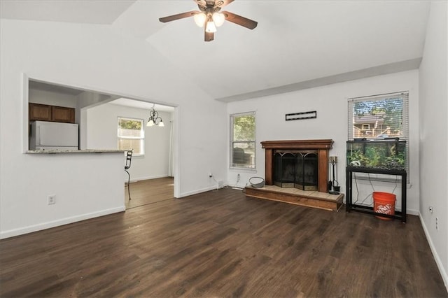 1916 NE Patterson Dr, Lees Summit, MO 64086 - unfurnished living room featuring ceiling fan, a fireplace with raised hearth, vaulted ceiling, dark wood-style flooring, and a chandelier