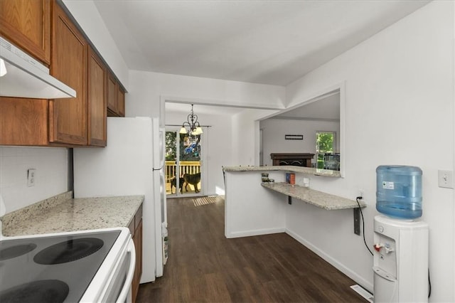 1916 NE Patterson Dr, Lees Summit, MO 64086 - kitchen featuring under cabinet range hood, brown cabinets, dark wood-style floors, and a chandelier