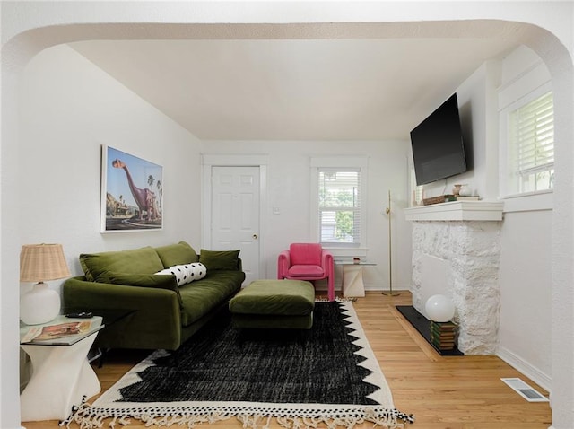 4206 Mission Rd, Kansas City, KS 66103 - living area with light wood-type flooring, arched walkways, and a fireplace with flush hearth
