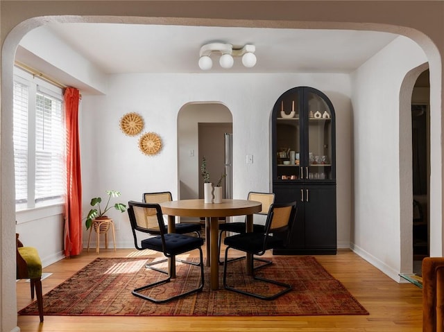 4206 Mission Rd, Kansas City, KS 66103 - dining area featuring light wood finished floors and arched walkways