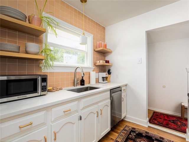4206 Mission Rd, Kansas City, KS 66103 - kitchen with appliances with stainless steel finishes, open shelves, decorative backsplash, light wood-style floors, and white cabinets