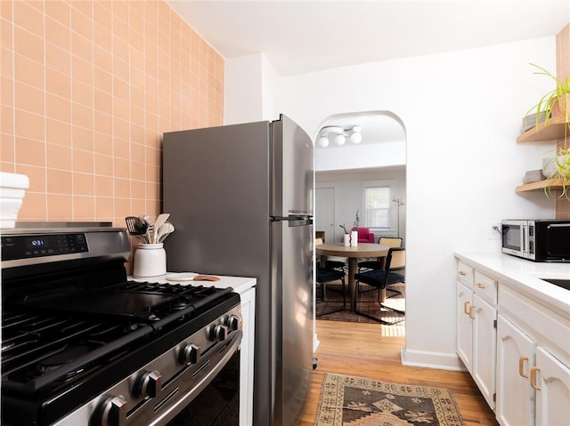 4206 Mission Rd, Kansas City, KS 66103 - kitchen featuring stainless steel appliances, light wood-style flooring, white cabinets, open shelves, and light countertops