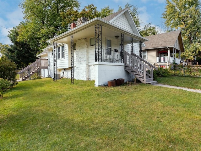 4206 Mission Rd, Kansas City, KS 66103 - view of front of property featuring stairs, covered porch, a chimney, and a front yard