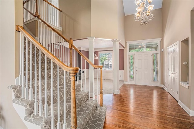14622 S Garnett St, Olathe, KS 66062 - entryway with wood finished floors, a towering ceiling, stairs, a chandelier, and ornate columns