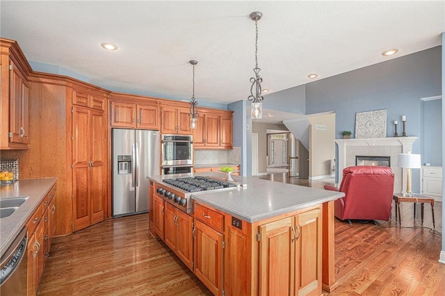 14622 S Garnett St, Olathe, KS 66062 - kitchen with stainless steel appliances, light wood-style flooring, decorative backsplash, a center island, and recessed lighting