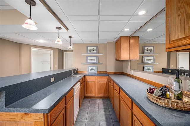 14622 S Garnett St, Olathe, KS 66062 - kitchen with a peninsula, dark countertops, a paneled ceiling, dark tile patterned floors, and brown cabinets