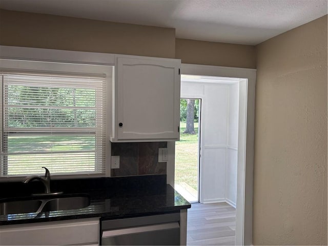 4202 Dr Greaves Rd, Grandview, MO 64030 - kitchen featuring dishwasher, white cabinetry, backsplash, wood finished floors, and dark stone countertops