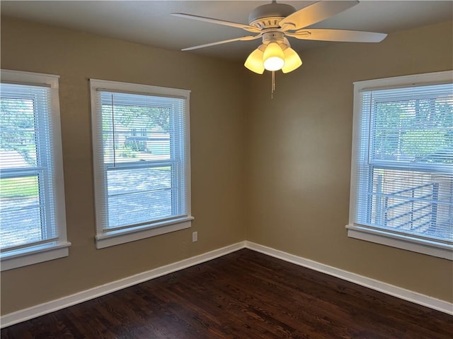 4202 Dr Greaves Rd, Grandview, MO 64030 - spare room featuring dark wood finished floors, plenty of natural light, and a ceiling fan