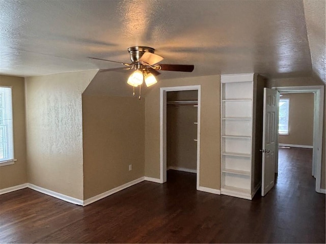 4202 Dr Greaves Rd, Grandview, MO 64030 - unfurnished bedroom with multiple windows, dark wood-style floors, a textured ceiling, and a ceiling fan