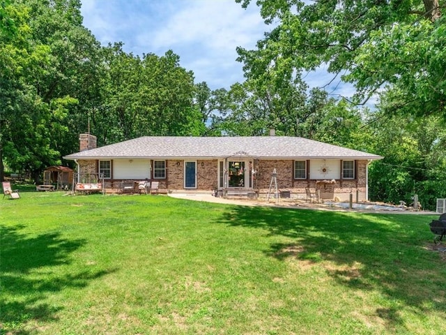 1490 216th St, Lathrop, MO 64465 - view of front of property with brick siding, a chimney, and a front lawn