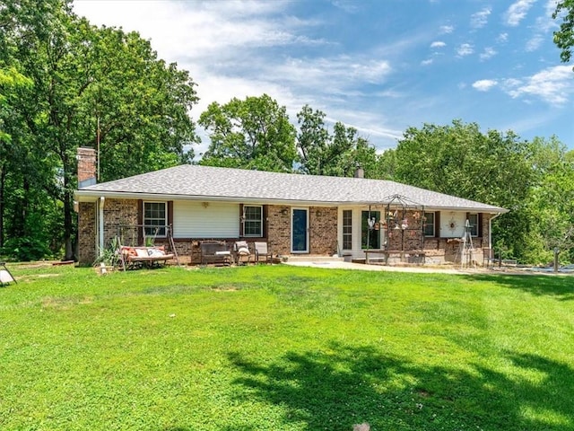 1490 216th St, Lathrop, MO 64465 - rear view of house with a chimney, brick siding, a yard, and a patio area
