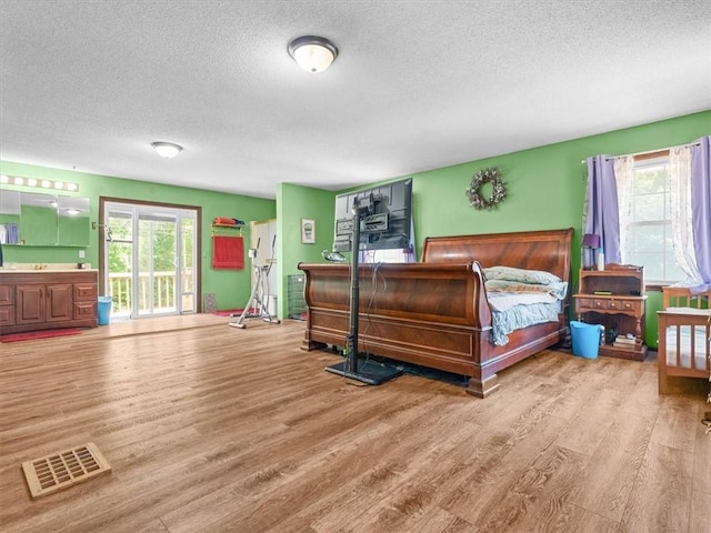 1490 216th St, Lathrop, MO 64465 - bedroom with a textured ceiling, wood finished floors, and access to outside