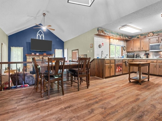 1490 216th St, Lathrop, MO 64465 - dining space featuring light wood-style floors, a ceiling fan, lofted ceiling, and a textured ceiling