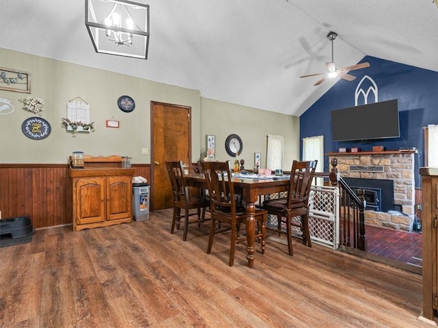 1490 216th St, Lathrop, MO 64465 - dining space with wood finished floors, vaulted ceiling, a ceiling fan, a wainscoted wall, and a fireplace