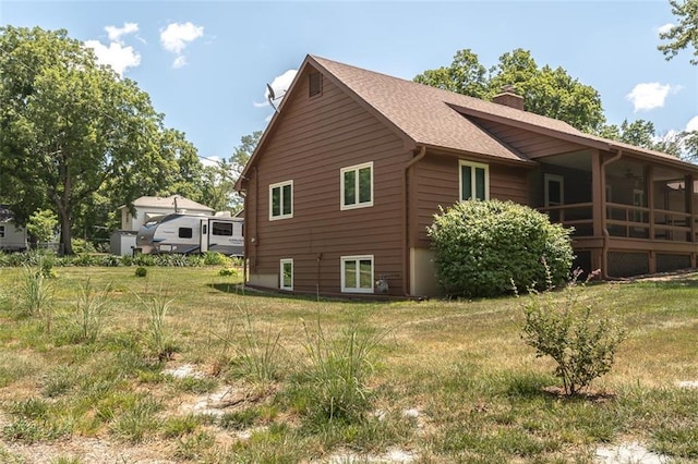 918 King St, Baldwin City, KS 66006 - view of property exterior featuring a chimney, roof with shingles, and a lawn