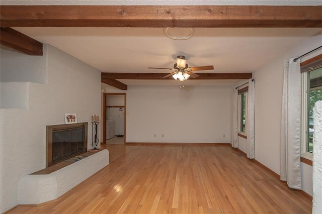 918 King St, Baldwin City, KS 66006 - unfurnished living room with beamed ceiling, a glass covered fireplace, light wood finished floors, and a ceiling fan