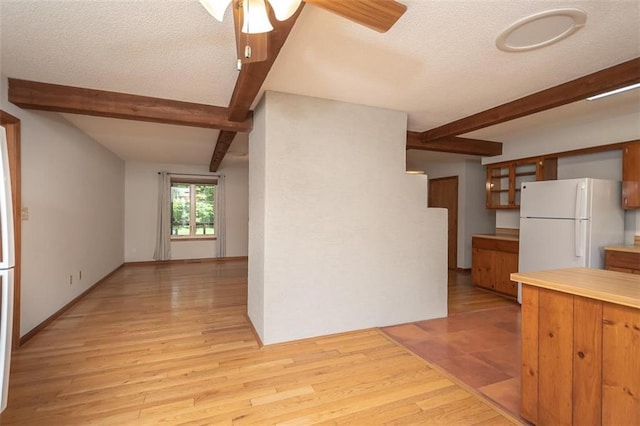 918 King St, Baldwin City, KS 66006 - kitchen featuring beamed ceiling, freestanding refrigerator, a ceiling fan, light wood-style floors, and light countertops