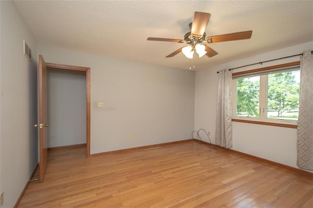 918 King St, Baldwin City, KS 66006 - empty room with light wood finished floors, a ceiling fan, and a textured ceiling