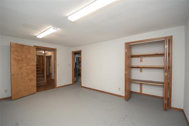 918 King St, Baldwin City, KS 66006 - unfurnished bedroom featuring a walk in closet and a textured ceiling