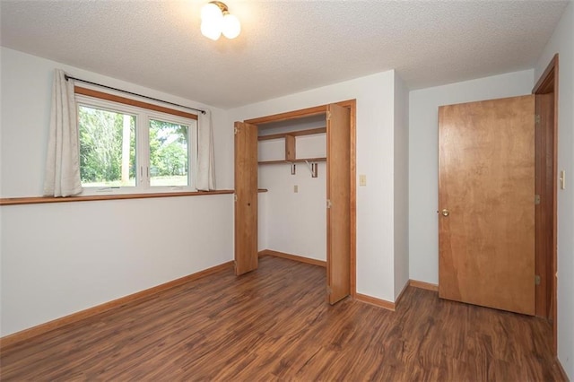 918 King St, Baldwin City, KS 66006 - unfurnished bedroom featuring wood finished floors, a textured ceiling, and a closet