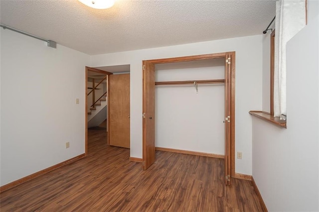 918 King St, Baldwin City, KS 66006 - unfurnished bedroom featuring wood finished floors, a closet, and a textured ceiling