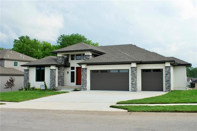 12820 N Arbor Way, Platte City, MO 64079 - prairie-style house featuring an attached garage, a front yard, concrete driveway, stone siding, and roof with shingles