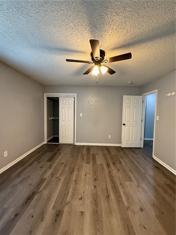401-07 NE Highland Ln, Blue Springs, MO 64014 - unfurnished bedroom with dark wood-style flooring, a closet, a textured ceiling, and ceiling fan