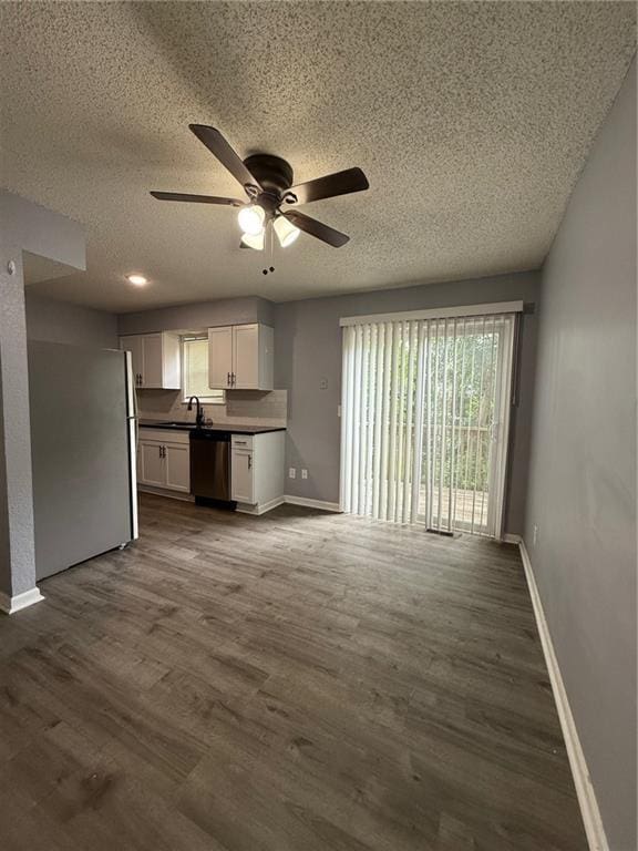 401-07 NE Highland Ln, Blue Springs, MO 64014 - unfurnished living room with ceiling fan, a textured ceiling, and dark wood finished floors