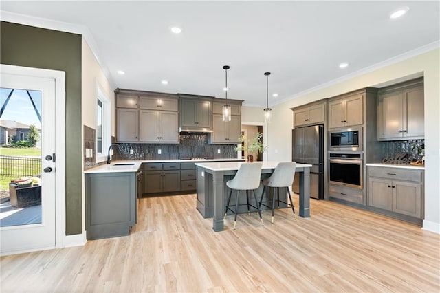 2768 SW 12th Ter, Lees Summit, MO 64081 - kitchen with stainless steel appliances, gray cabinetry, a kitchen bar, backsplash, and ornamental molding