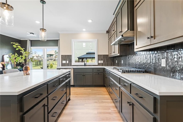 2768 SW 12th Ter, Lees Summit, MO 64081 - kitchen featuring stainless steel appliances, light wood-style floors, crown molding, light countertops, and decorative backsplash