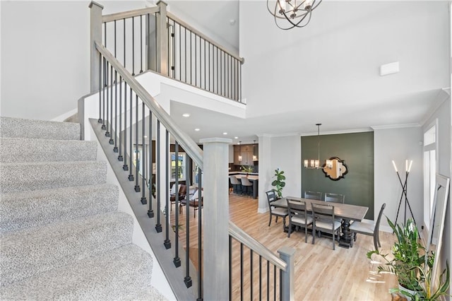 2768 SW 12th Ter, Lees Summit, MO 64081 - stairway featuring a chandelier, wood finished floors, ornamental molding, and a towering ceiling