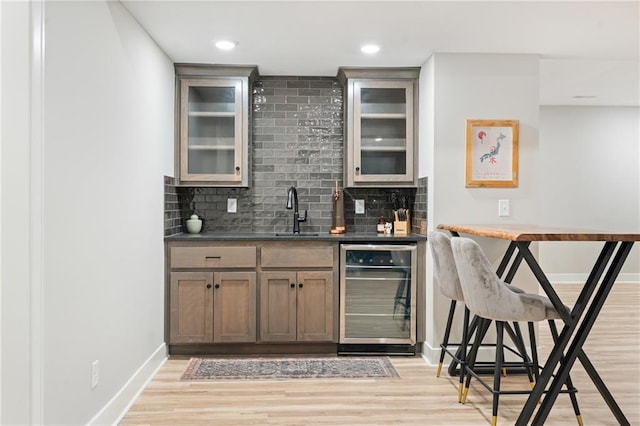 2768 SW 12th Ter, Lees Summit, MO 64081 - indoor wet bar featuring wine cooler, decorative backsplash, light wood-style floors, and recessed lighting