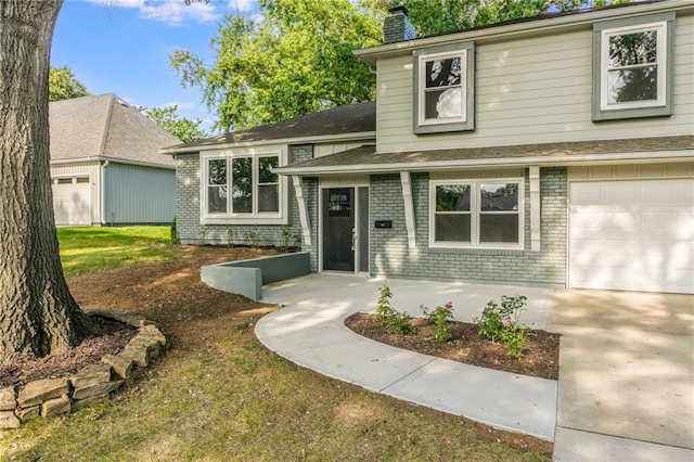9909 Juniper Ln, Overland Park, KS 66207 - tri-level home with brick siding, a chimney, and a garage