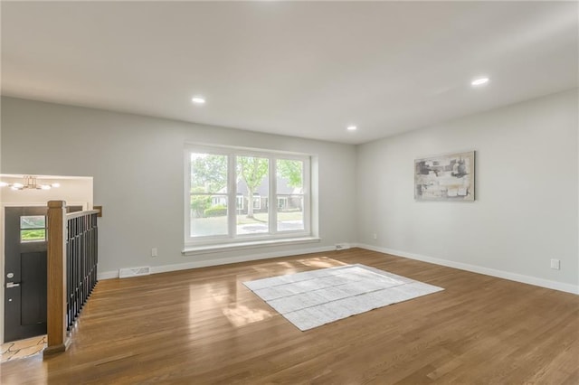 9909 Juniper Ln, Overland Park, KS 66207 - unfurnished living room featuring wood finished floors, a chandelier, and recessed lighting