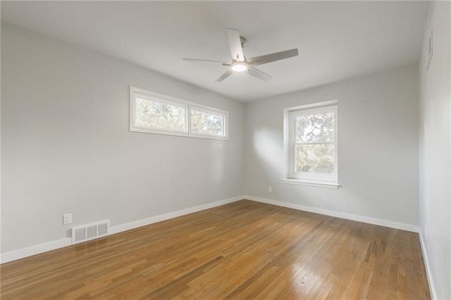 9909 Juniper Ln, Overland Park, KS 66207 - unfurnished room featuring healthy amount of natural light, wood finished floors, and ceiling fan